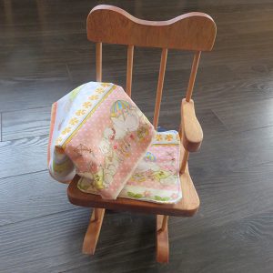 Rocking chair with cushion and matching doll blanket.
